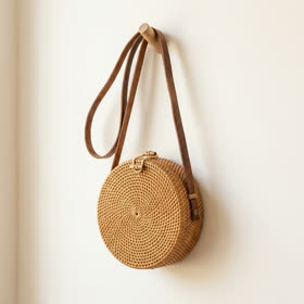 The round rattan bag hanging from a wall peg