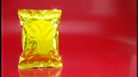 A shiny gold pouch against a red background